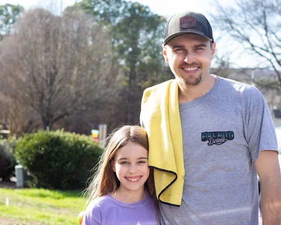 Cavan, owner of Full Auto Detail, smiling with his daughter